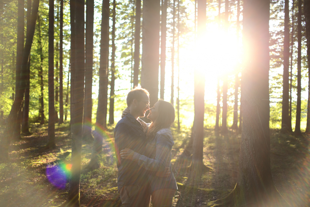 Verliebtes Pärchen küsst sich im Sonnenuntergang im Wald Couple Shooting